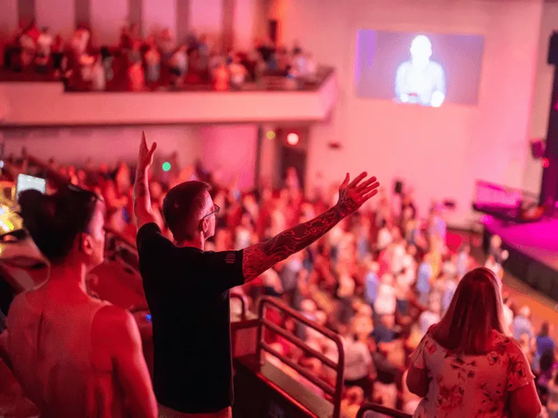Church service with people raising their hands in worship