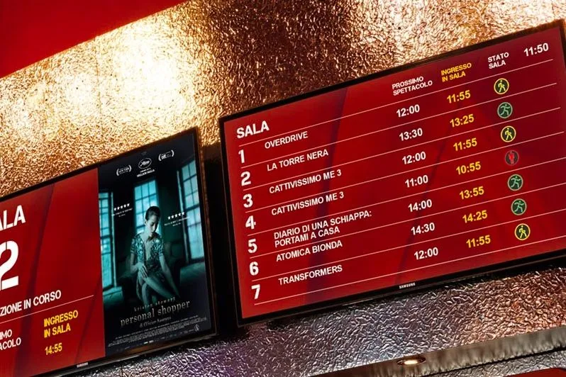 Digital boards with movie showtimes in a cinema lobby
