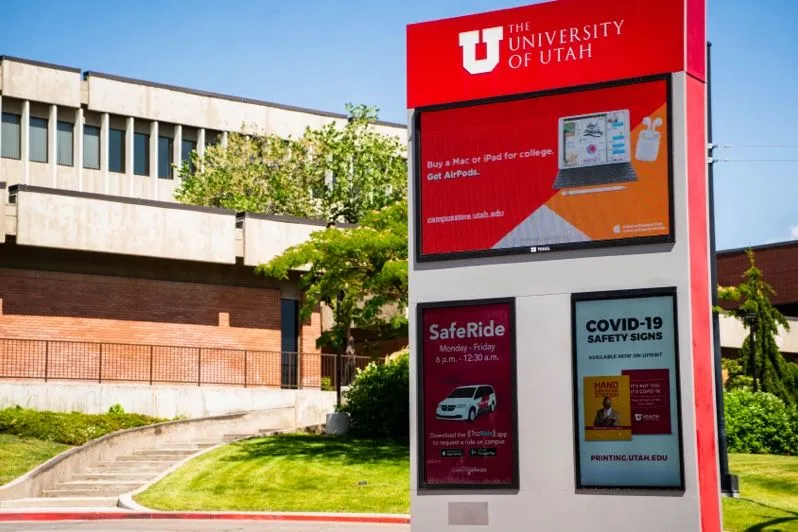 Outdoor campus sign with digital screens at the University of Utah