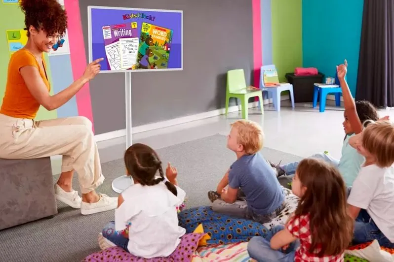 Teacher and children in a classroom with a screen on a stand