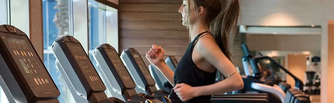 People running on treadmills in a gym