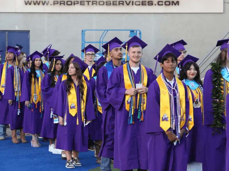 Graduates in purple gowns at a graduation ceremony