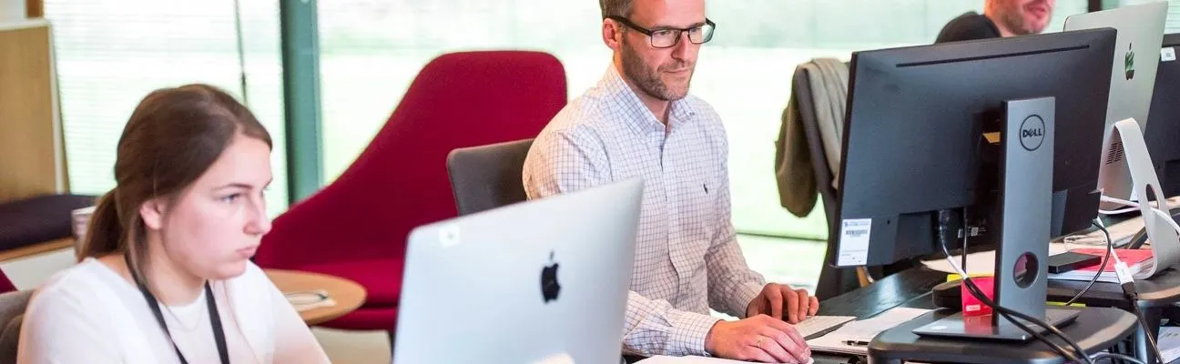 People working at desks in an open-plan office